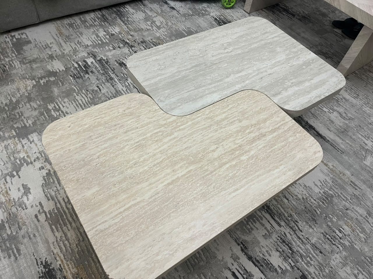 A modern two-piece coffee table set featuring an interlocking geometric design in beige, with a pattern that mimics stone or travertine. - Image 4