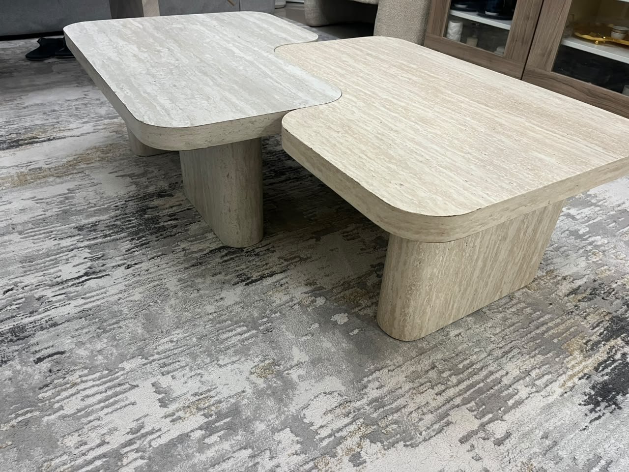 A modern two-piece coffee table set featuring an interlocking geometric design in beige, with a pattern that mimics stone or travertine. - Image 9