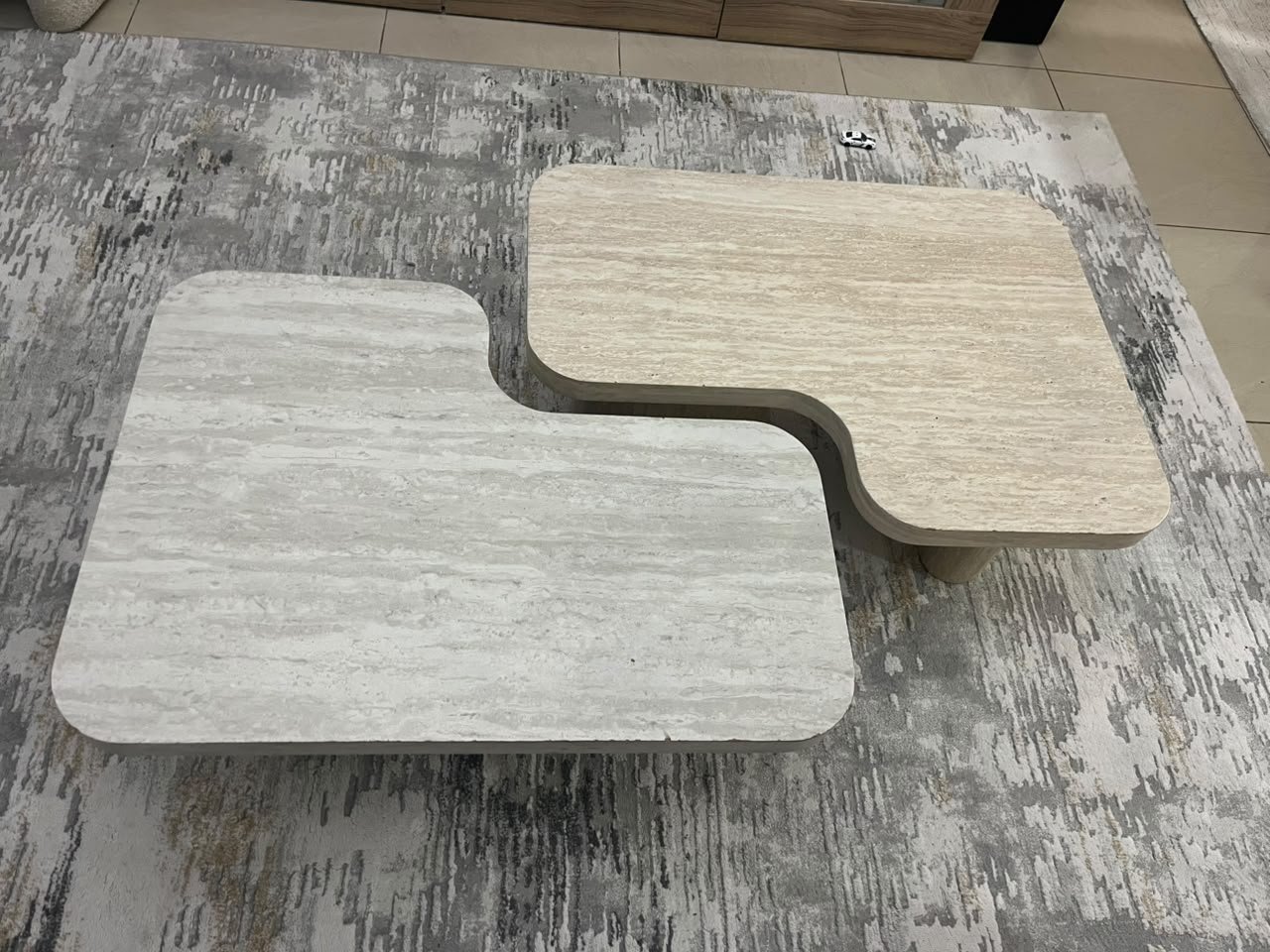 A modern two-piece coffee table set featuring an interlocking geometric design in beige, with a pattern that mimics stone or travertine. - Image 8