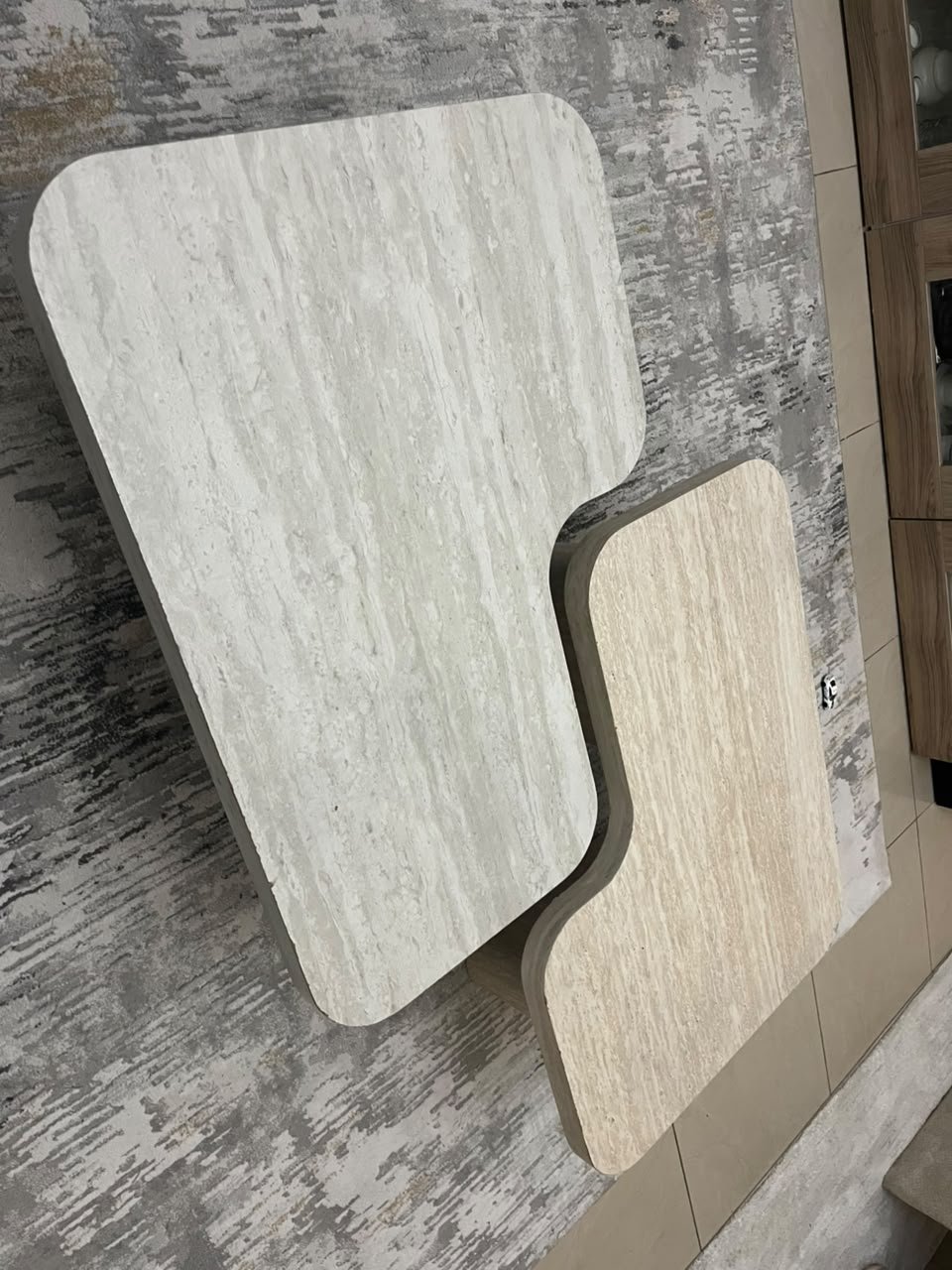 A modern two-piece coffee table set featuring an interlocking geometric design in beige, with a pattern that mimics stone or travertine. - Image 5