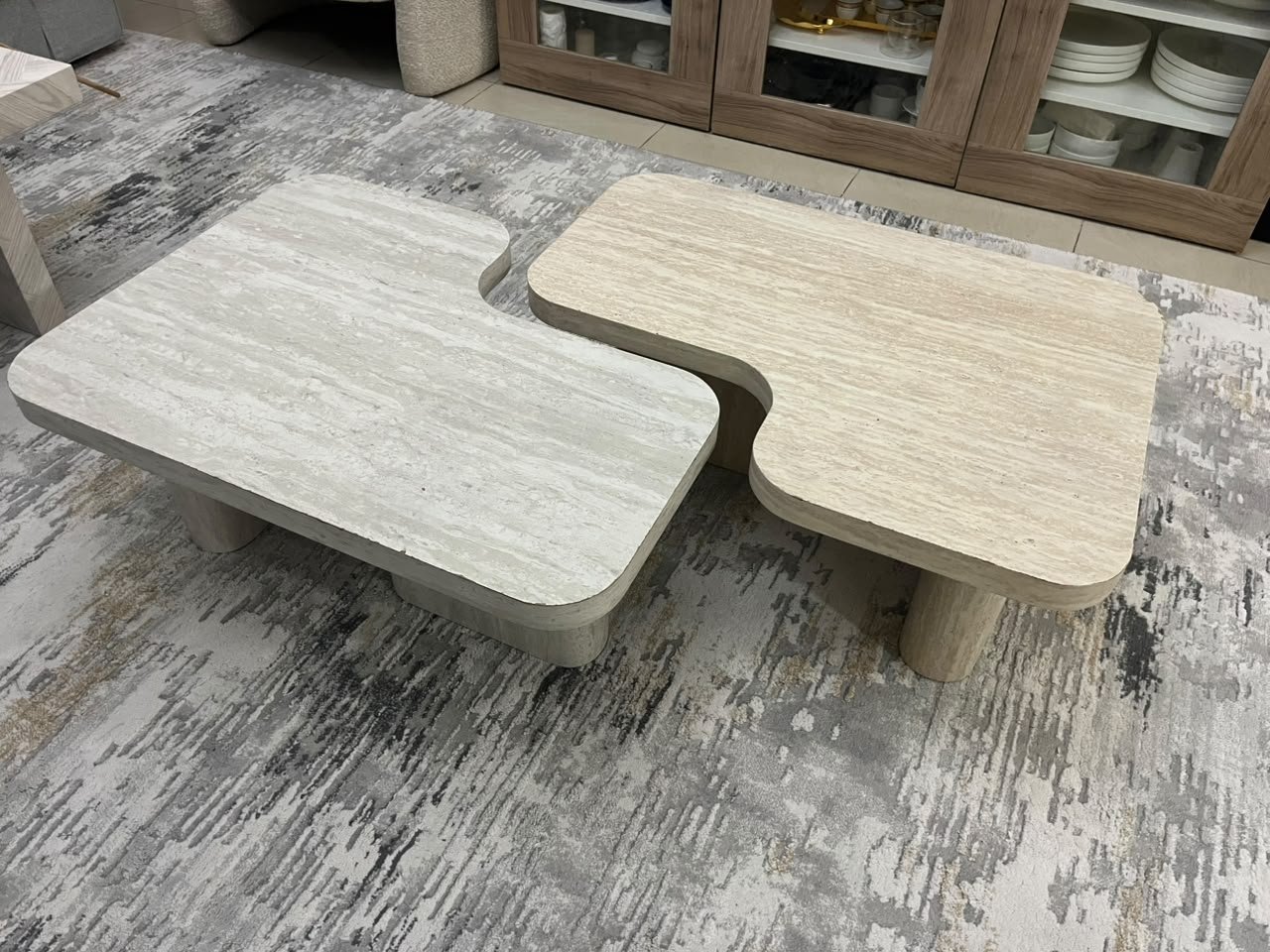 A modern two-piece coffee table set featuring an interlocking geometric design in beige, with a pattern that mimics stone or travertine. - Image 6