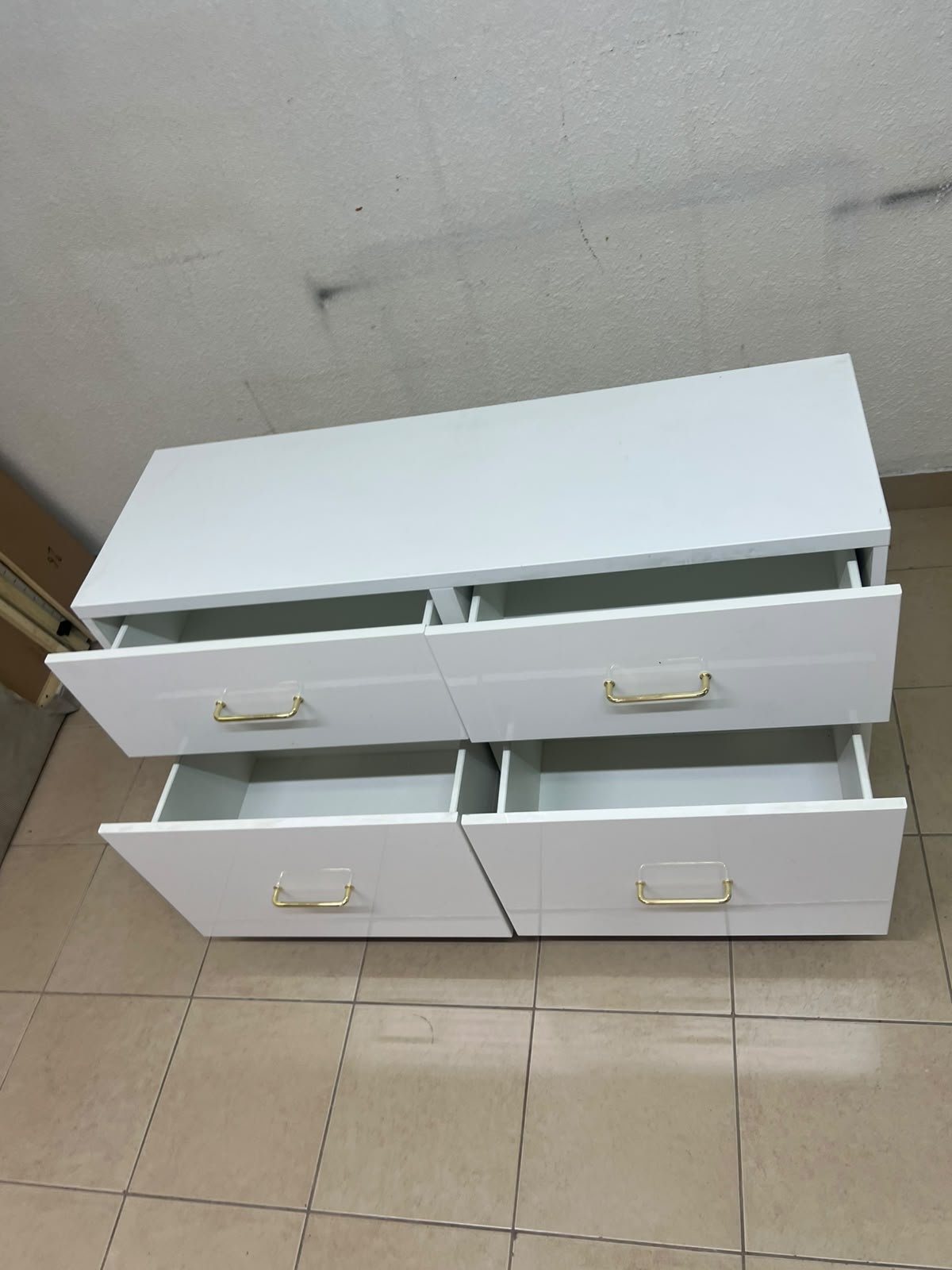 A modern, low-profile white chest of drawers (dresser) featuring a soft white finish, four spacious drawers (or double-fronted drawers), and gold or copper-toned pulls, all set on raised white legs. The design resembles contemporary storage units like the IKEA BESTÅ system or similar four-drawer cabinets. - Image 9