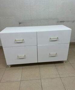 A modern, low-profile white chest of drawers (dresser) featuring a soft white finish, four spacious drawers (or double-fronted drawers), and gold or copper-toned pulls, all set on raised white legs. The design resembles contemporary storage units like the IKEA BESTÅ system or similar four-drawer cabinets.