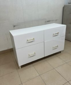 A modern, low-profile white chest of drawers (dresser) featuring a soft white finish, four spacious drawers (or double-fronted drawers), and gold or copper-toned pulls, all set on raised white legs. The design resembles contemporary storage units like the IKEA BESTÅ system or similar four-drawer cabinets. - Image 3