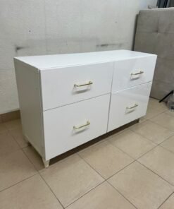 A modern, low-profile white chest of drawers (dresser) featuring a soft white finish, four spacious drawers (or double-fronted drawers), and gold or copper-toned pulls, all set on raised white legs. The design resembles contemporary storage units like the IKEA BESTÅ system or similar four-drawer cabinets. - Image 5