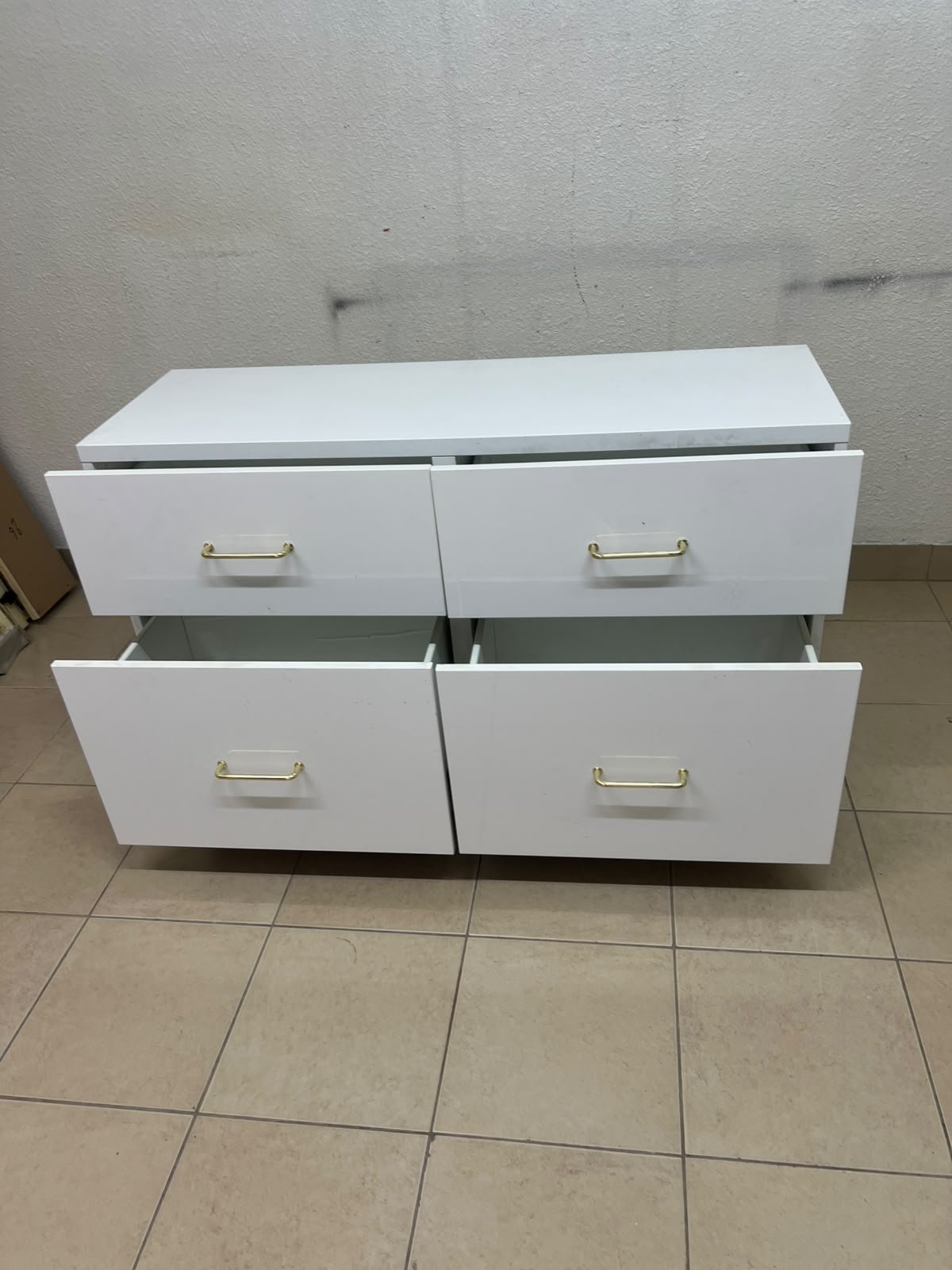 A modern, low-profile white chest of drawers (dresser) featuring a soft white finish, four spacious drawers (or double-fronted drawers), and gold or copper-toned pulls, all set on raised white legs. The design resembles contemporary storage units like the IKEA BESTÅ system or similar four-drawer cabinets. - Image 6