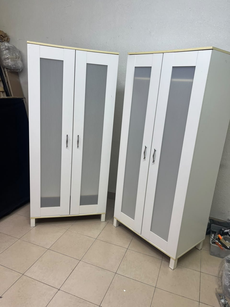 Two IKEA Aneboda wardrobes (or similar white, two-door models with ribbed-glass doors).