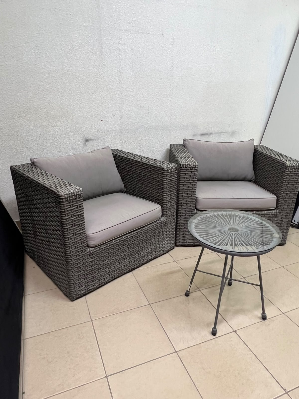 A compact outdoor seating set consisting of two grey synthetic rattan (PE Rattan) armchairs with comfortable grey cushions, plus a round table with a glass top. - Image 5