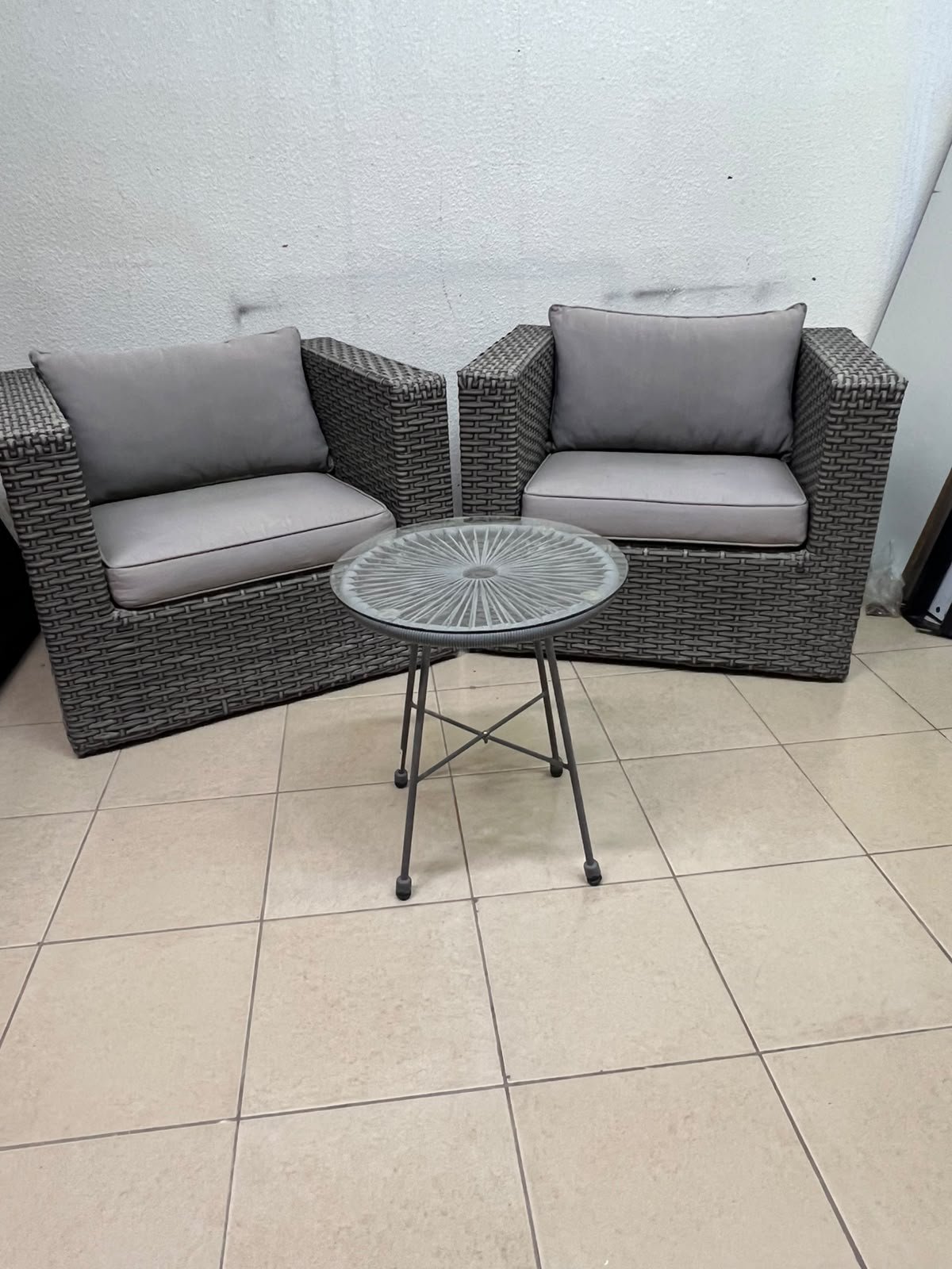 A compact outdoor seating set consisting of two grey synthetic rattan (PE Rattan) armchairs with comfortable grey cushions, plus a round table with a glass top. - Image 7