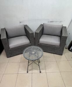 A compact outdoor seating set consisting of two grey synthetic rattan (PE Rattan) armchairs with comfortable grey cushions, plus a round table with a glass top. - Image 2