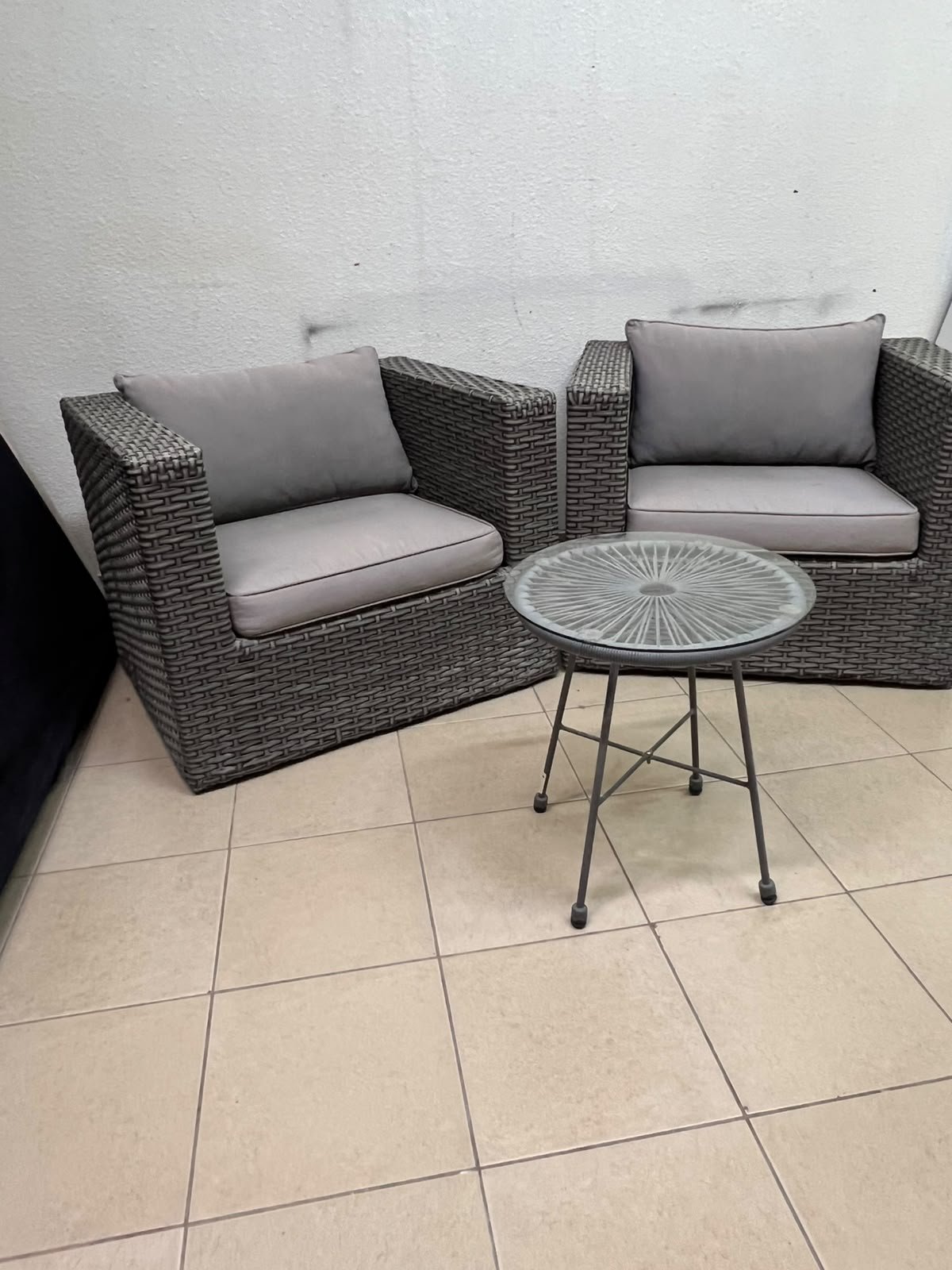 A compact outdoor seating set consisting of two grey synthetic rattan (PE Rattan) armchairs with comfortable grey cushions, plus a round table with a glass top. - Image 4