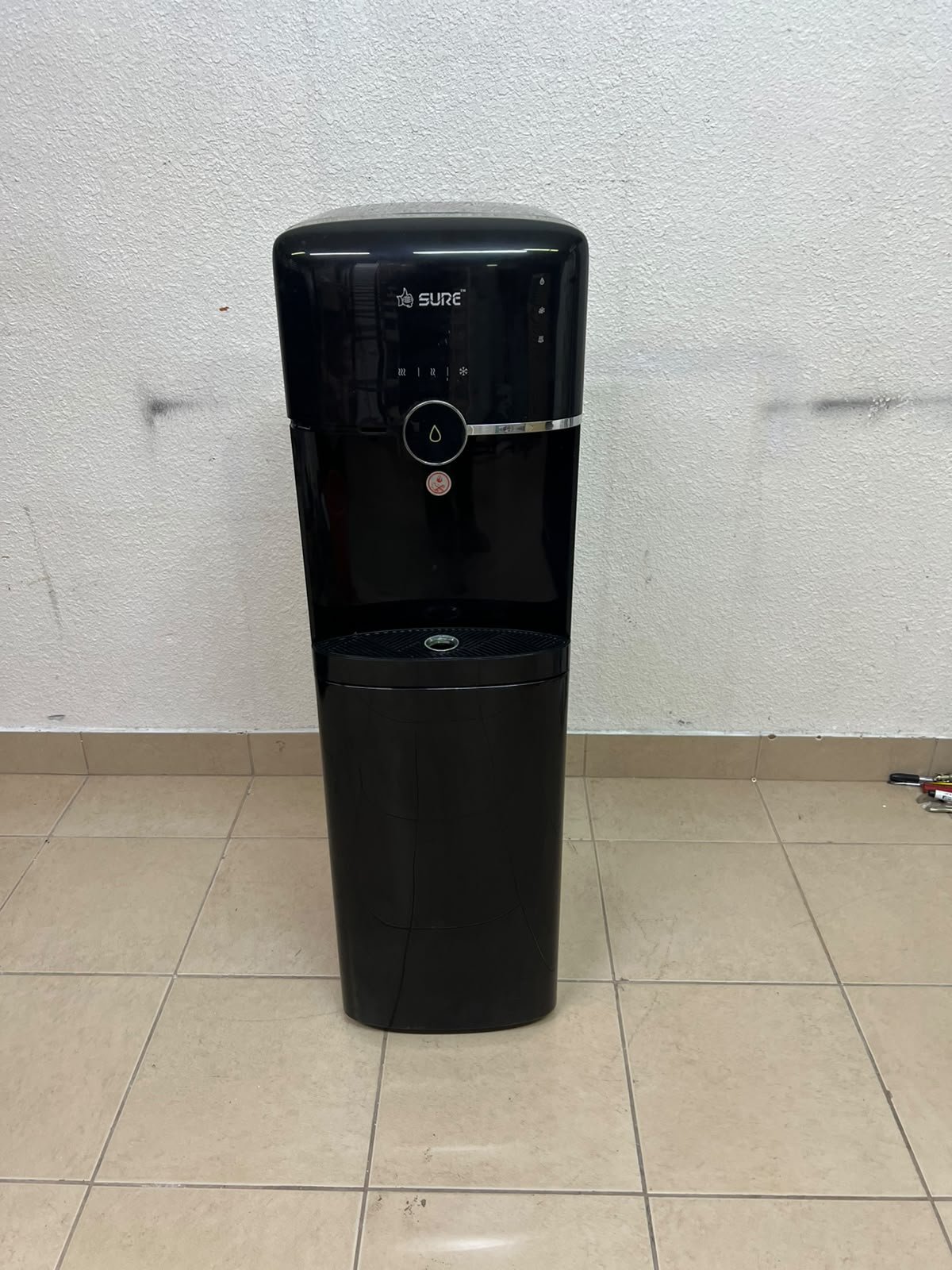 A black, freestanding water cooler from Sure—specifically a bottom-loading model (such as the SBL70 or SBL1970BP)—that allows the water bottle to be easily placed inside the bottom compartment. - Image 4