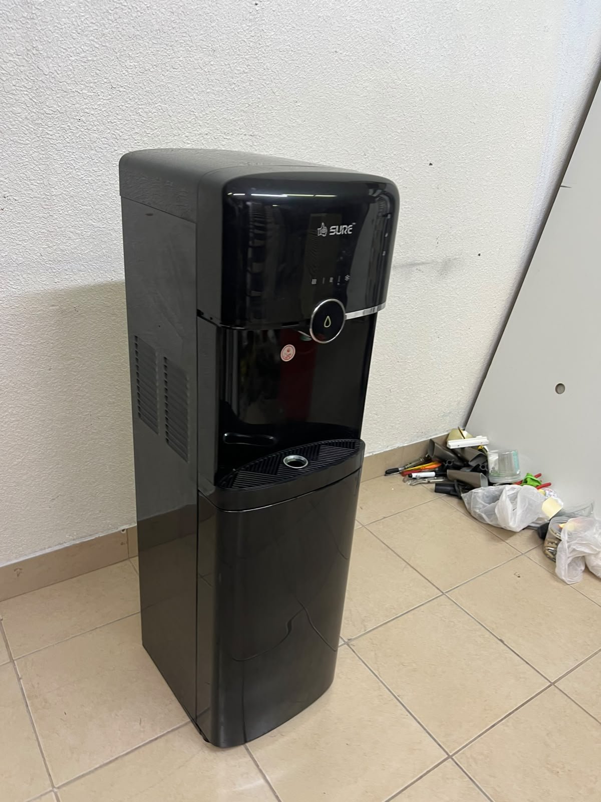A black, freestanding water cooler from Sure—specifically a bottom-loading model (such as the SBL70 or SBL1970BP)—that allows the water bottle to be easily placed inside the bottom compartment. - Image 5