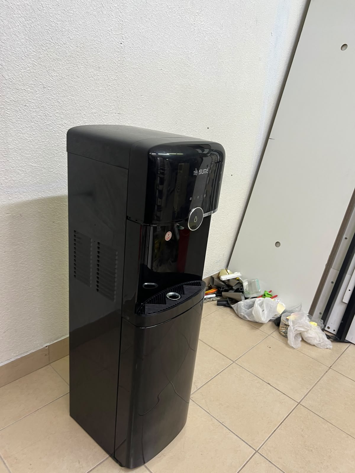 A black, freestanding water cooler from Sure—specifically a bottom-loading model (such as the SBL70 or SBL1970BP)—that allows the water bottle to be easily placed inside the bottom compartment. - Image 8