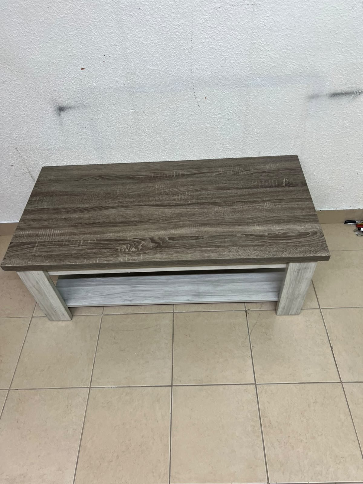 A rectangular coffee table made of engineered wood featuring a two-tone design; the tabletop comes in a greyish-brown wood finish, while the frame, legs, and lower shelf are white or light grey. It resembles the "Angelic" coffee table from Home Box. - Image 3