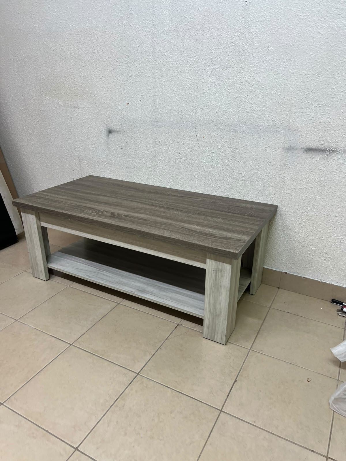 A rectangular coffee table made of engineered wood featuring a two-tone design; the tabletop comes in a greyish-brown wood finish, while the frame, legs, and lower shelf are white or light grey. It resembles the "Angelic" coffee table from Home Box. - Image 5