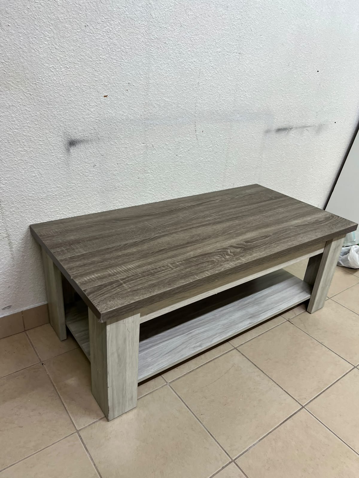 A rectangular coffee table made of engineered wood featuring a two-tone design; the tabletop comes in a greyish-brown wood finish, while the frame, legs, and lower shelf are white or light grey. It resembles the "Angelic" coffee table from Home Box. - Image 6