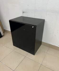 An IKEA BESTÅ series storage cabinet, featuring a high-gloss black door (Selsviken front).