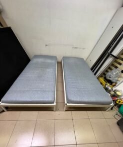 Two single beds with white metal frames, featuring lightweight foam mattresses in a light gray/blue color—similar to the ÅGOTNES foam mattress from IKEA. - Image 5