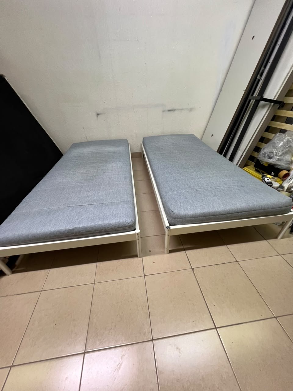 Two single beds with white metal frames, featuring lightweight foam mattresses in a light gray/blue color—similar to the ÅGOTNES foam mattress from IKEA. - Image 2