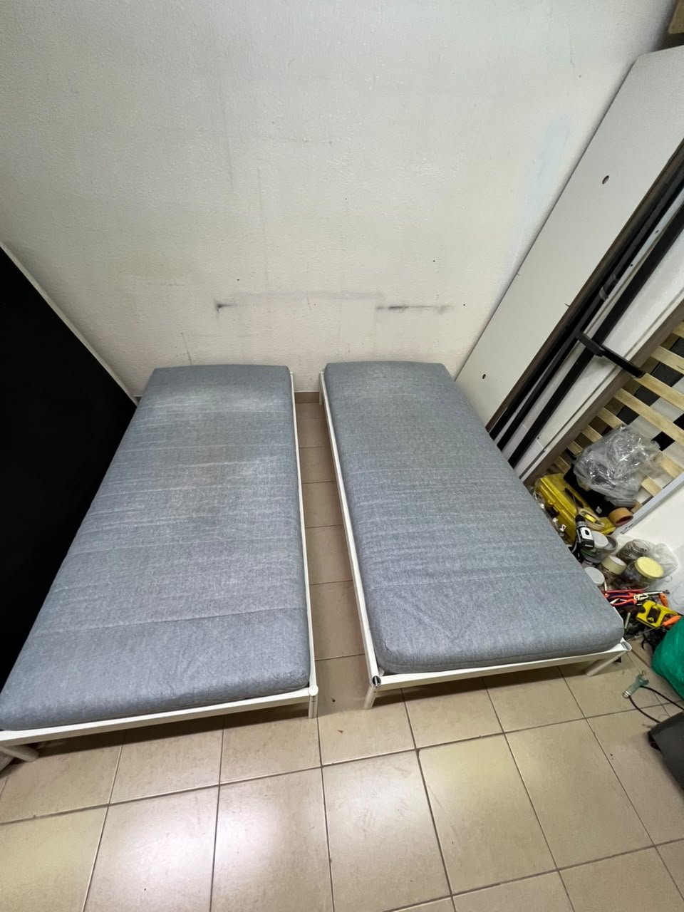 Two single beds with white metal frames, featuring lightweight foam mattresses in a light gray/blue color—similar to the ÅGOTNES foam mattress from IKEA. - Image 3