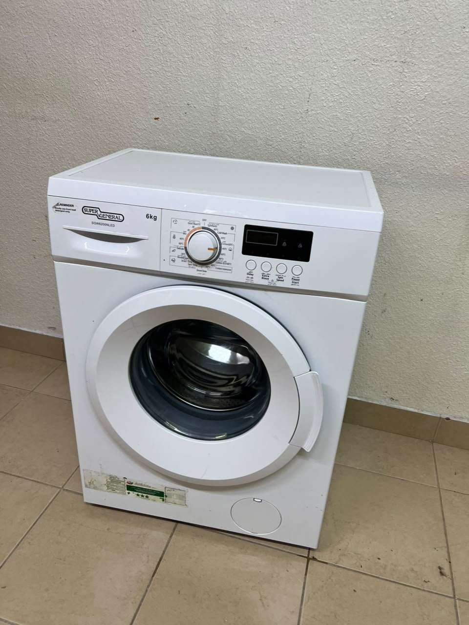 The image shows a Super General front-load washing machine (6 kg capacity, 1000 RPM, model similar to SGW6100NLED).