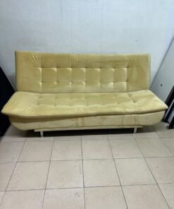 yellow velvet sofa bed with a tufted, segmented design.