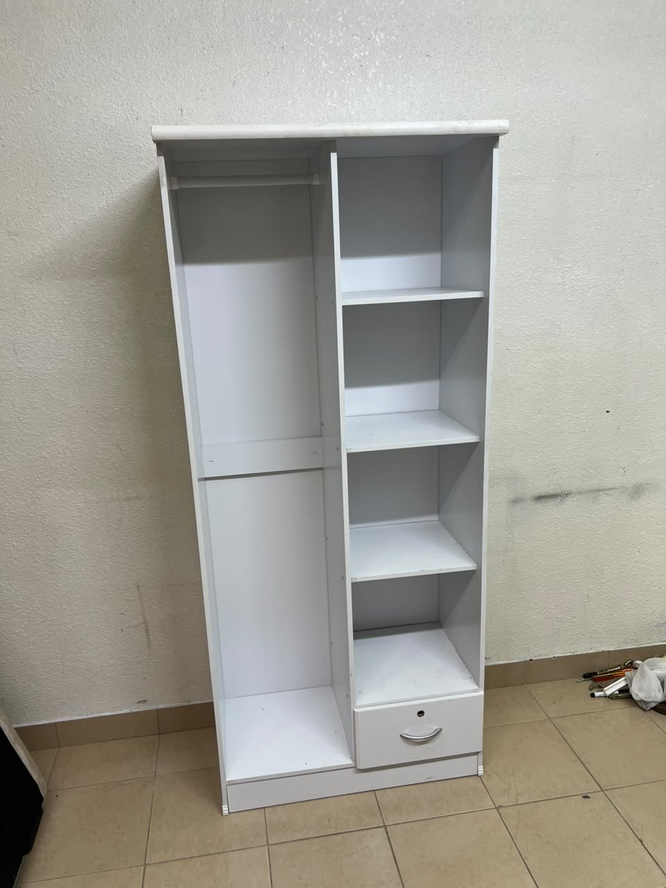 A freestanding, white, geometric wooden wardrobe (closet).