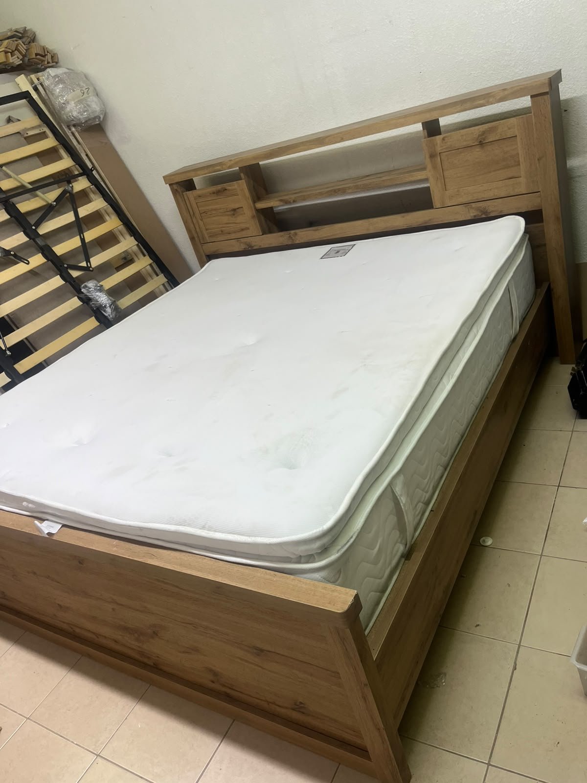 A modern-style wooden double bed (king or queen size) with a mattress, featuring a headboard equipped with shelves and storage cabinets—from Home Centre. - Image 12