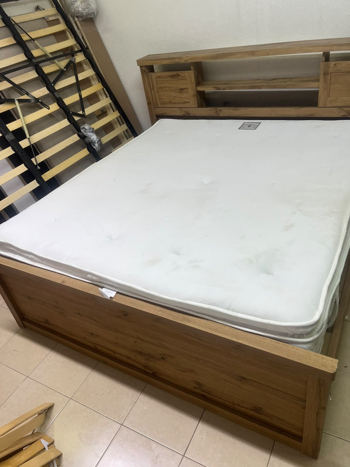 A modern-style wooden double bed (king or queen size) with a mattress, featuring a headboard equipped with shelves and storage cabinets—from Home Centre. - Image 13