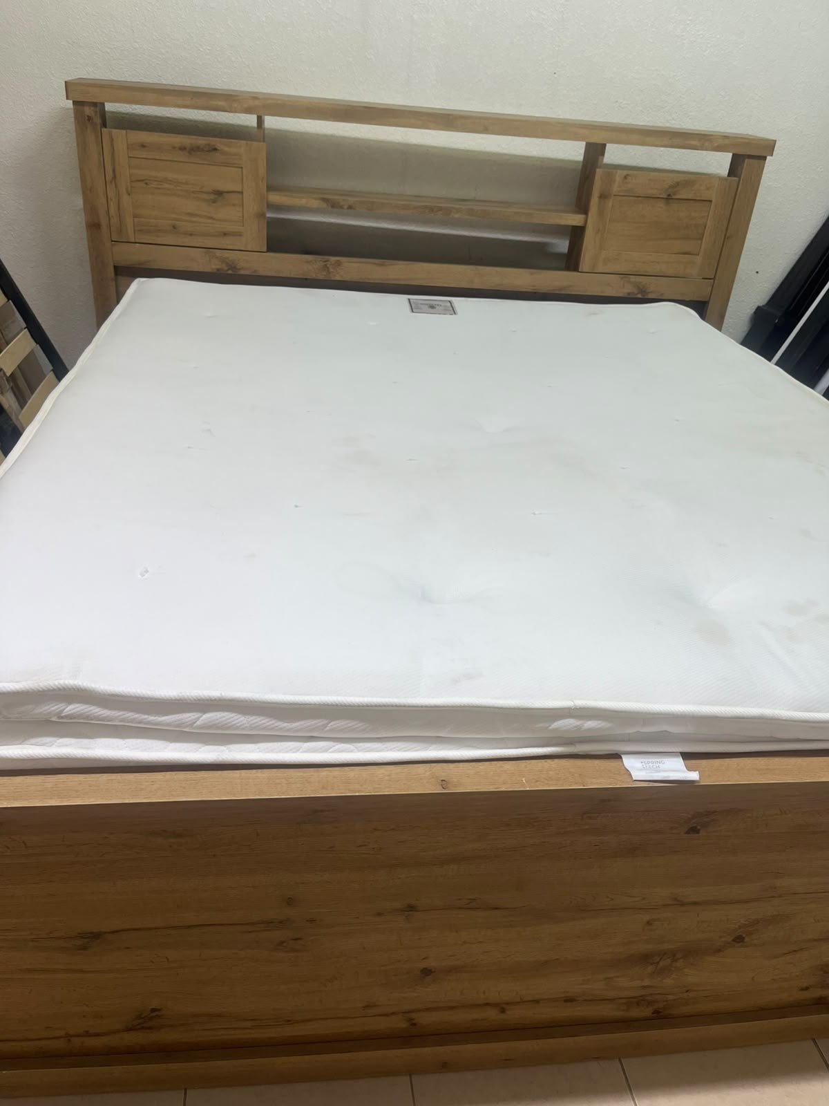 A modern-style wooden double bed (king or queen size) with a mattress, featuring a headboard equipped with shelves and storage cabinets—from Home Centre. - Image 2