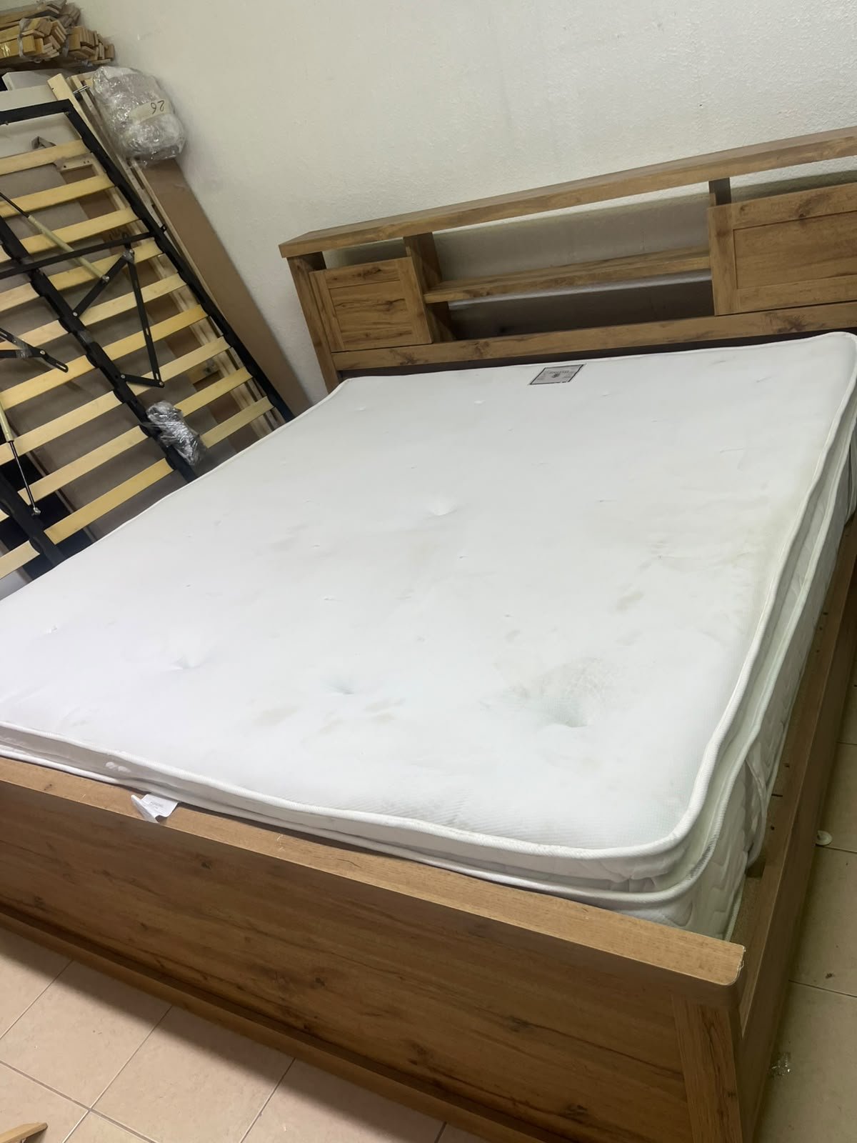 A modern-style wooden double bed (king or queen size) with a mattress, featuring a headboard equipped with shelves and storage cabinets—from Home Centre. - Image 4