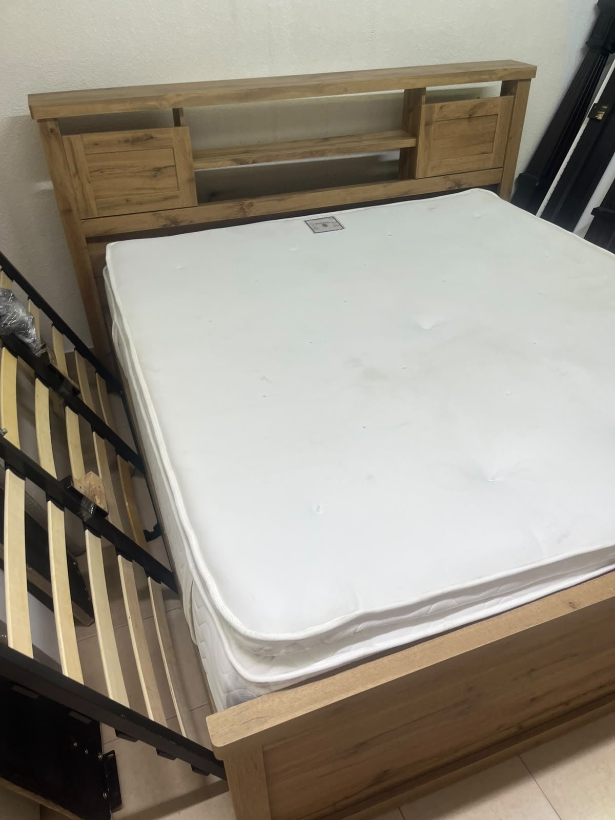 A modern-style wooden double bed (king or queen size) with a mattress, featuring a headboard equipped with shelves and storage cabinets—from Home Centre. - Image 5