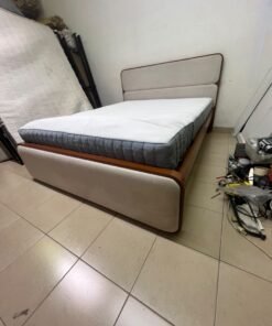 A bed with a mattress, featuring a solid wood frame—such as the "Oboro" or "Nordome" models available at Danube Home—in a super king size (160×200 cm), finished in beige with a brown wooden frame.