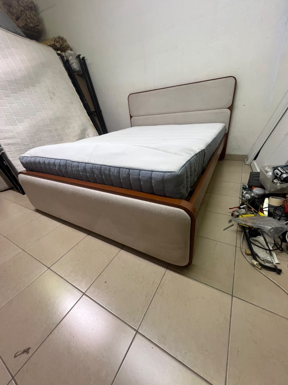 A bed with a mattress, featuring a solid wood frame—such as the "Oboro" or "Nordome" models available at Danube Home—in a super king size (160×200 cm), finished in beige with a brown wooden frame.
