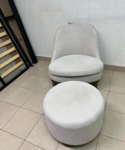 An armchair (poltrona) with a matching footstool (pouffe), featuring a modern, curved design; upholstered in a light beige velvet or linen-like fabric and set upon elegant wooden legs. - Image 3