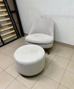 An armchair (poltrona) with a matching footstool (pouffe), featuring a modern, curved design; upholstered in a light beige velvet or linen-like fabric and set upon elegant wooden legs. - Image 7