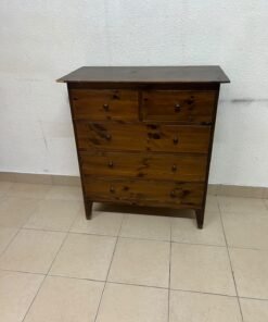A classic chest of drawers made of solid wood (such as pine or a darker wood), featuring two small drawers at the top and four large, full-width drawers below; it is accented with small, round knobs and elevated wooden legs.
