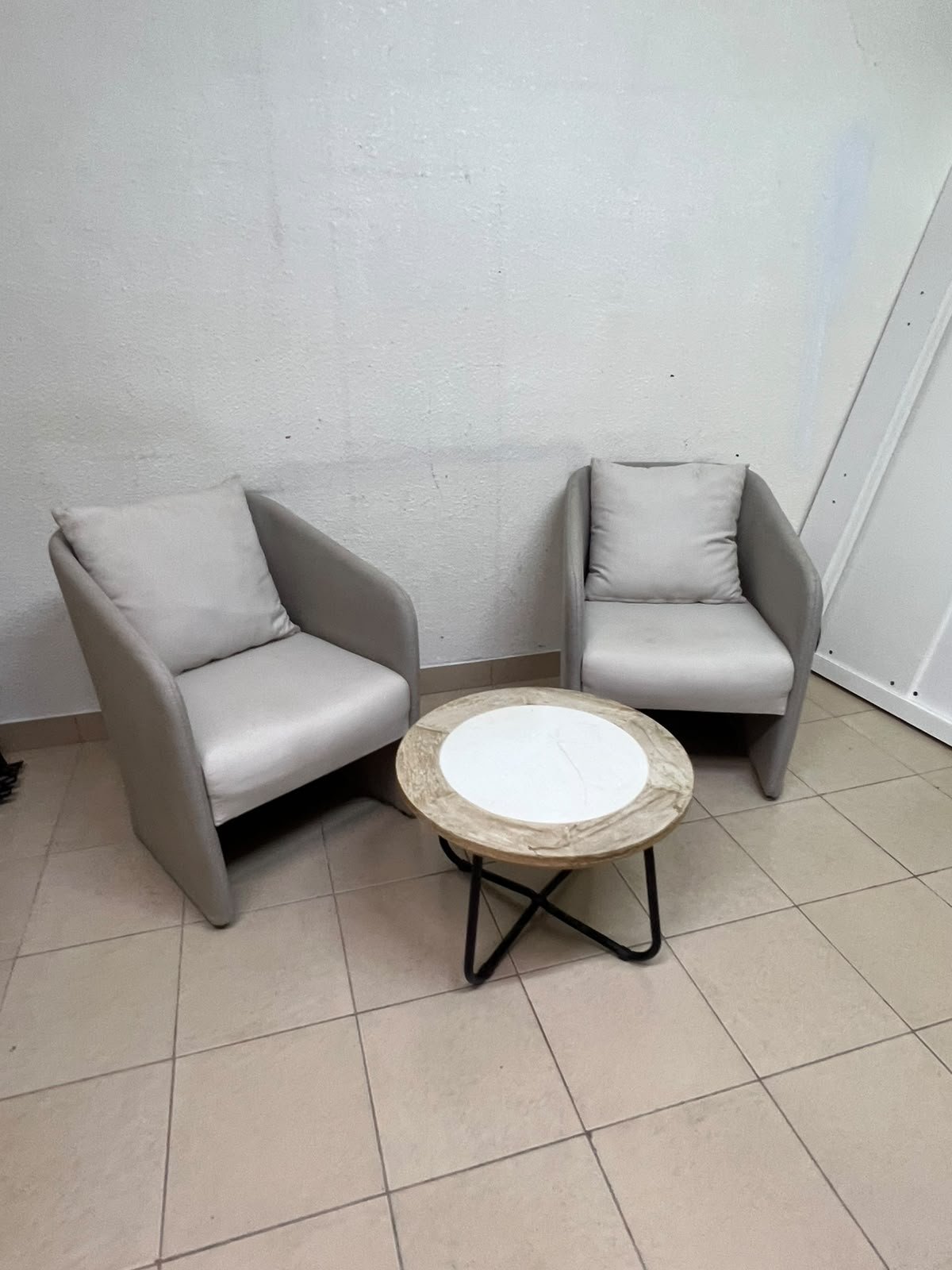 A seating set consisting of two individual grey chairs with square back cushions, with a small, round coffee table—featuring a white top and a black metal base—placed between them. - Image 7