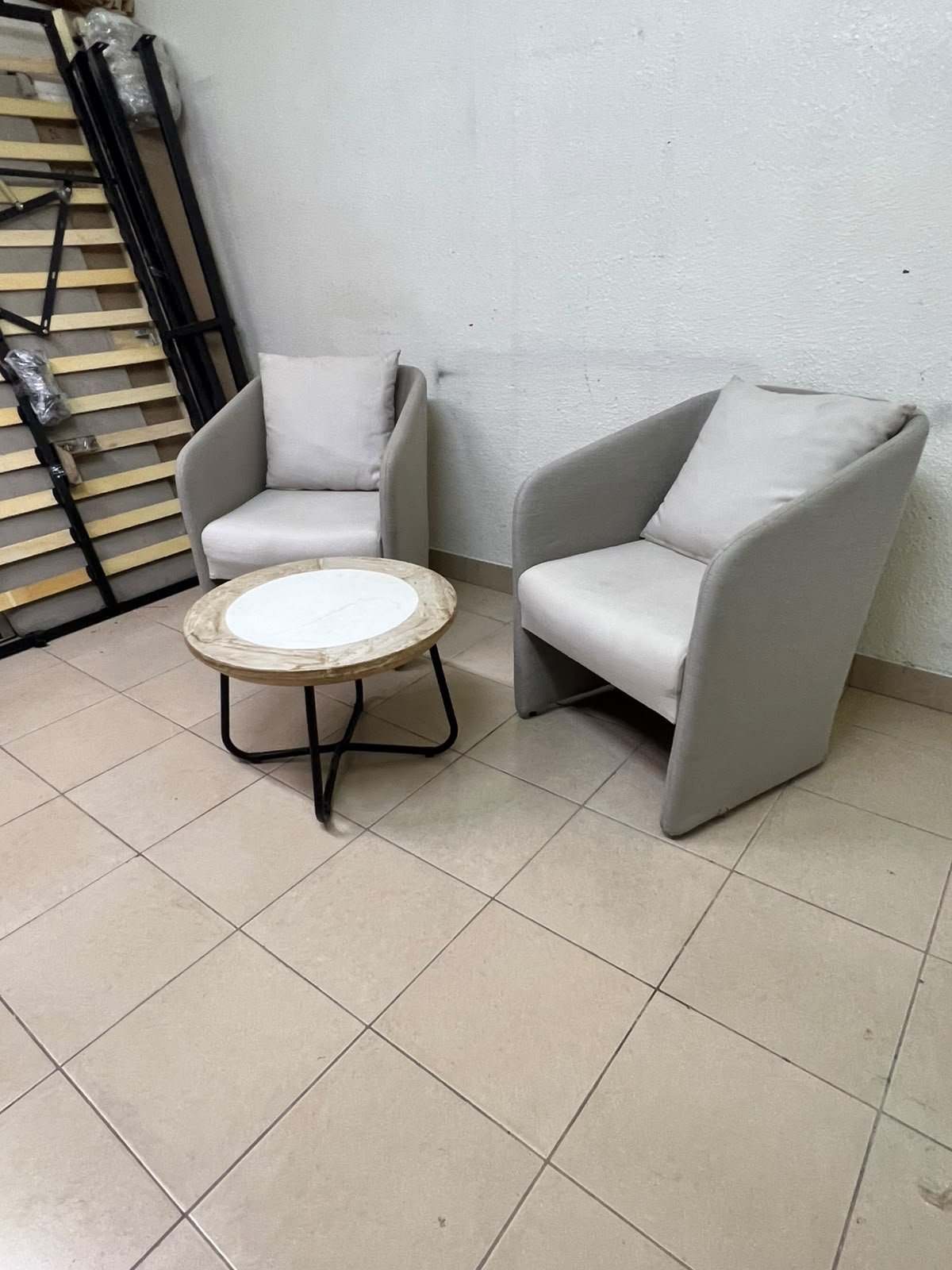 A seating set consisting of two individual grey chairs with square back cushions, with a small, round coffee table—featuring a white top and a black metal base—placed between them. - Image 8