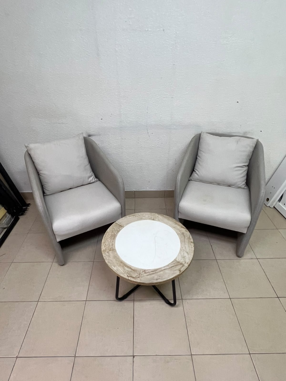 A seating set consisting of two individual grey chairs with square back cushions, with a small, round coffee table—featuring a white top and a black metal base—placed between them. - Image 10