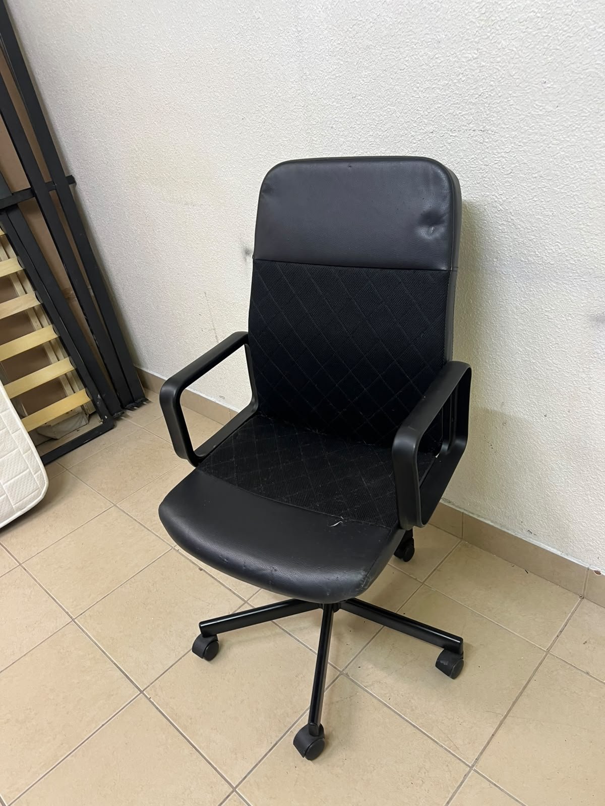 An IKEA swivel office chair known as the RENBERGET swivel chair, in black Bomstad.