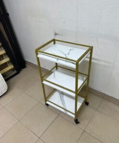 A 3-tier storage or serving cart on wheels, featuring a gold-colored metal frame and white, marble-design shelves. - Image 2