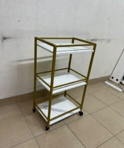 A 3-tier storage or serving cart on wheels, featuring a gold-colored metal frame and white, marble-design shelves. - Image 3