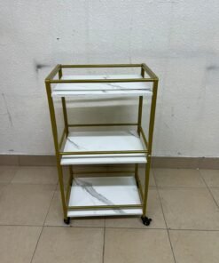 A 3-tier storage or serving cart on wheels, featuring a gold-colored metal frame and white, marble-design shelves. - Image 6