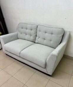 A light gray/beige two-seater fabric sofa featuring button-tufted backrests and short black legs; it closely resembles models such as the Pan Emirates Rosebond two-seater or the Pan Emirates Akli two-seater.