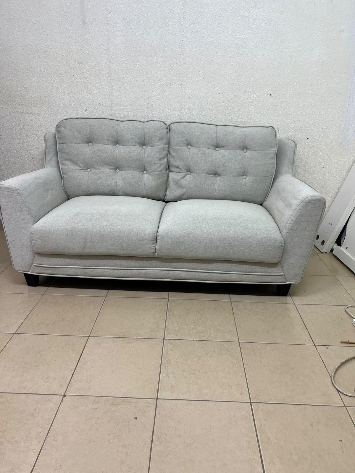A light gray/beige two-seater fabric sofa featuring button-tufted backrests and short black legs; it closely resembles models such as the Pan Emirates Rosebond two-seater or the Pan Emirates Akli two-seater. - Image 4