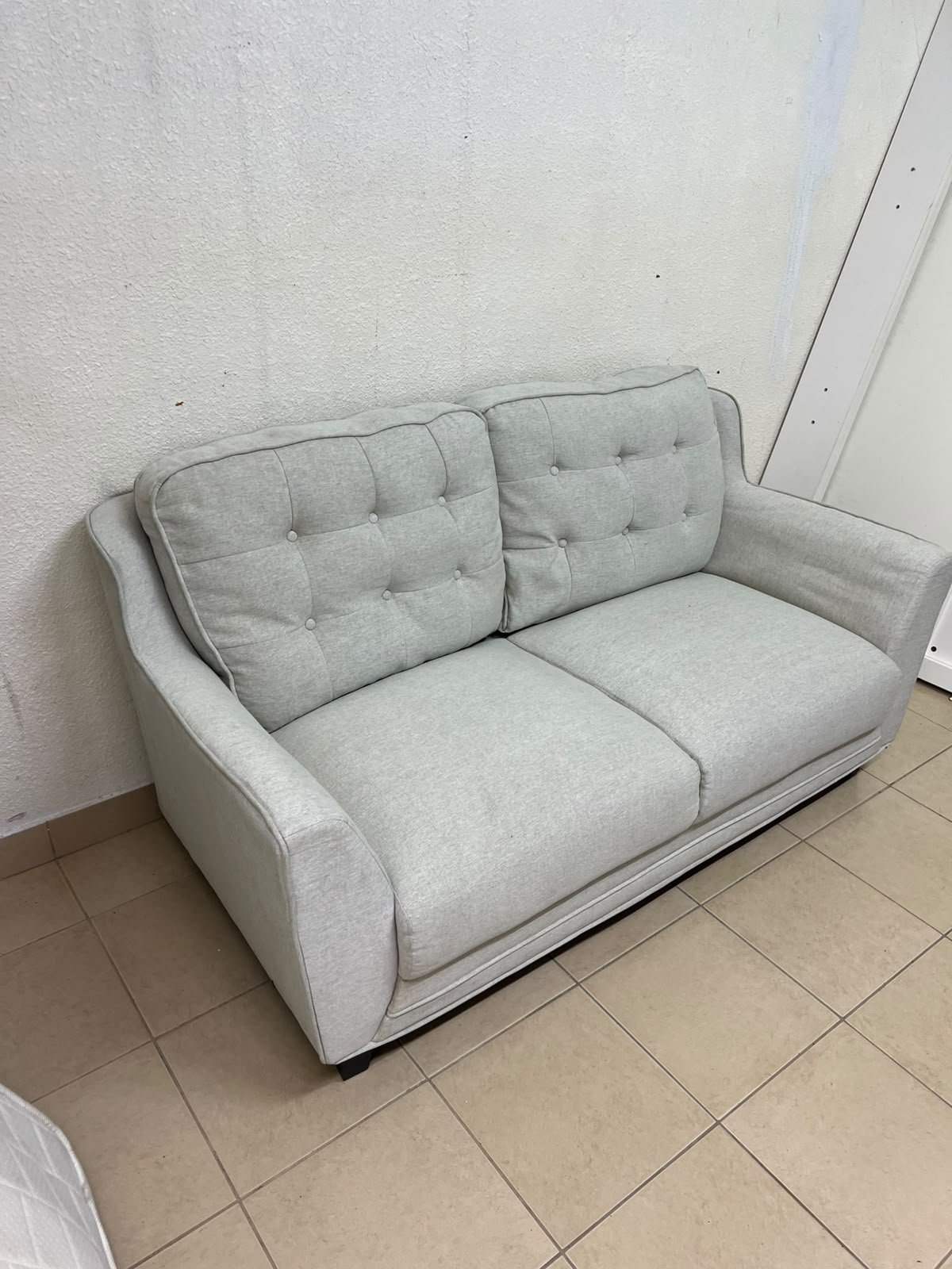 A light gray/beige two-seater fabric sofa featuring button-tufted backrests and short black legs; it closely resembles models such as the Pan Emirates Rosebond two-seater or the Pan Emirates Akli two-seater. - Image 5