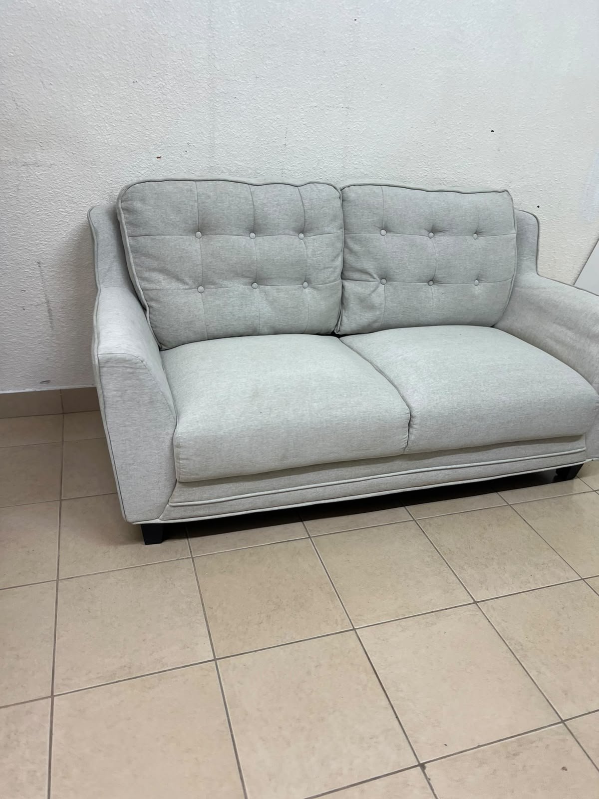 A light gray/beige two-seater fabric sofa featuring button-tufted backrests and short black legs; it closely resembles models such as the Pan Emirates Rosebond two-seater or the Pan Emirates Akli two-seater. - Image 6