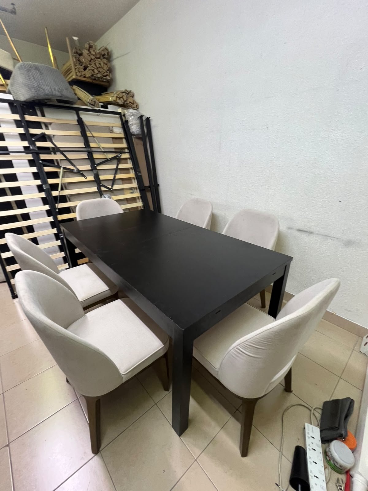 Dining table with 6 chairs: a black, rectangular, extendable wooden table paired with upholstered chairs in a light beige color – an IKEA dining set.